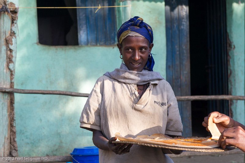 20120402_072109 Nikon D3S (1) 2x3.jpg - The Ethiopians are very kind and friendly.   The lady is offering some injera to our guide